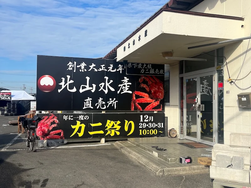 「創業大正元年 北山水産直売所」の看板とカニ祭り告知