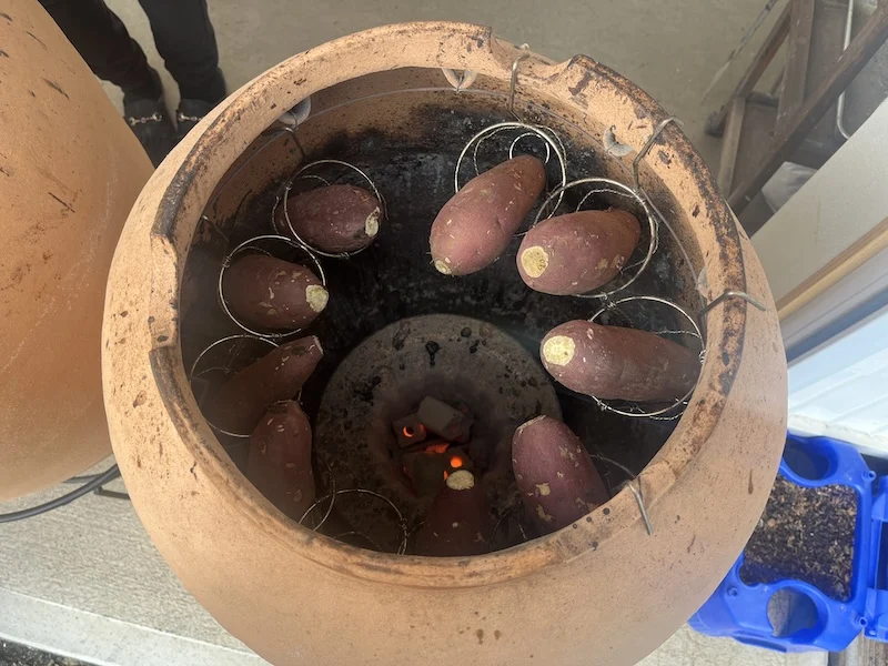 壺で焼かれる焼き芋の様子