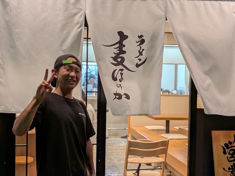お店の暖簾と気さくな店主
