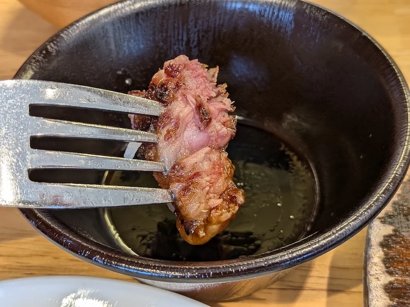 黒い小鉢のソースにくぐらせた松阪牛ステーキ