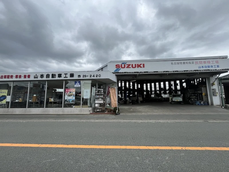 スズキの看板が目印の山本自動車工業と店先の自販機