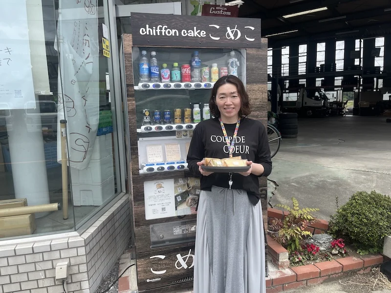 シフォンケーキを手に自販機の前に立つ作り手さん