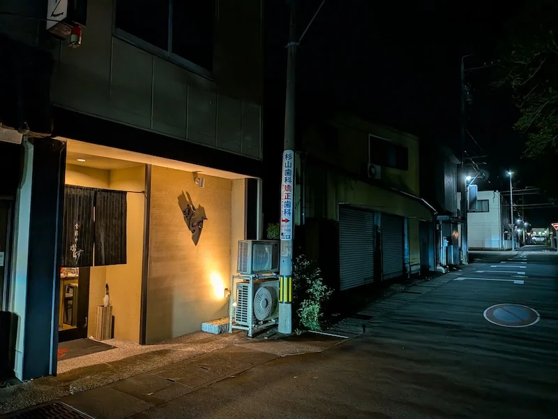 夜の路地に灯るお店の外観